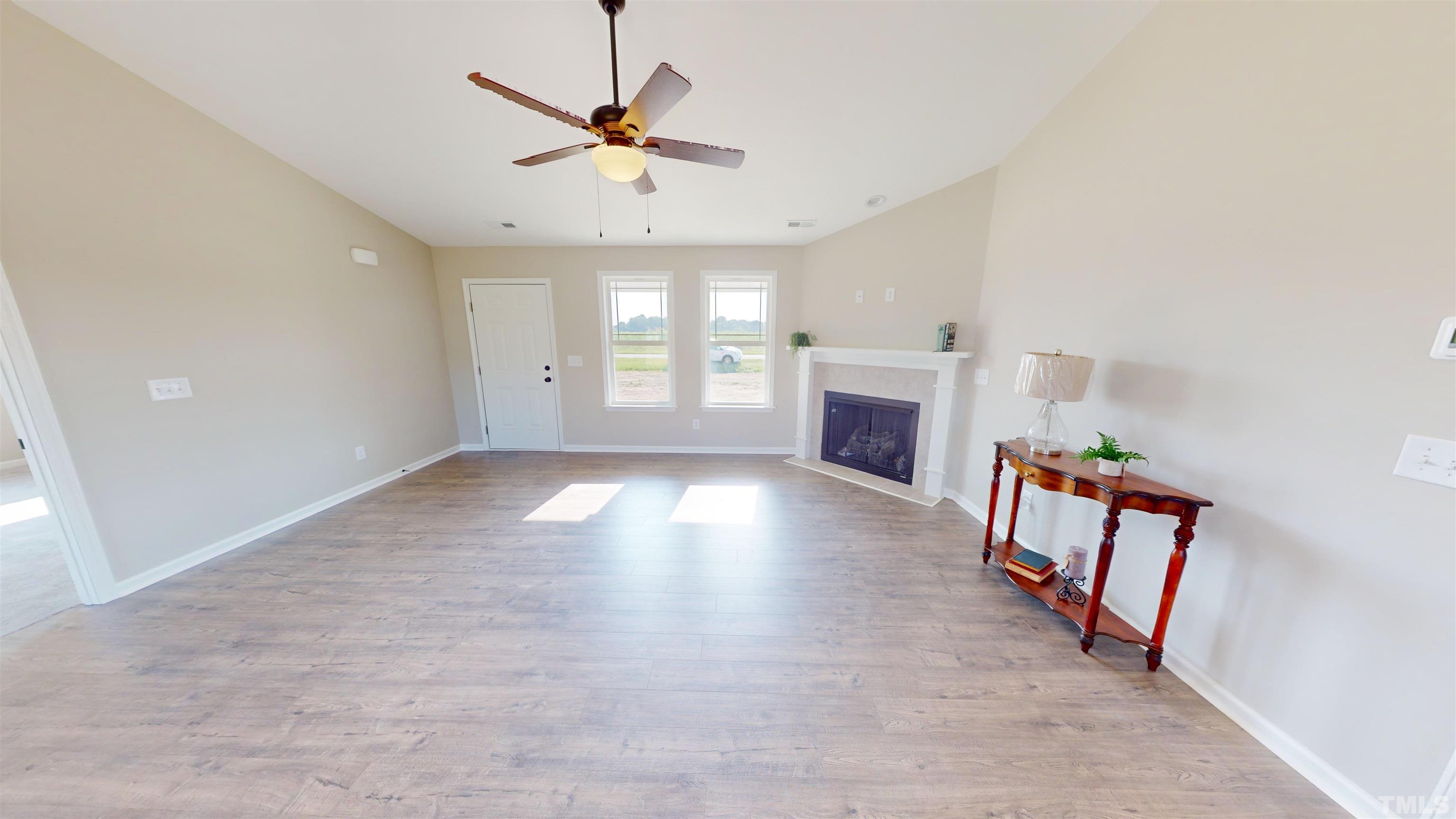 108 Mamie Road Benson, NC 27504 - Photo 11 of 31 wooden floor in an empty room with a fireplace