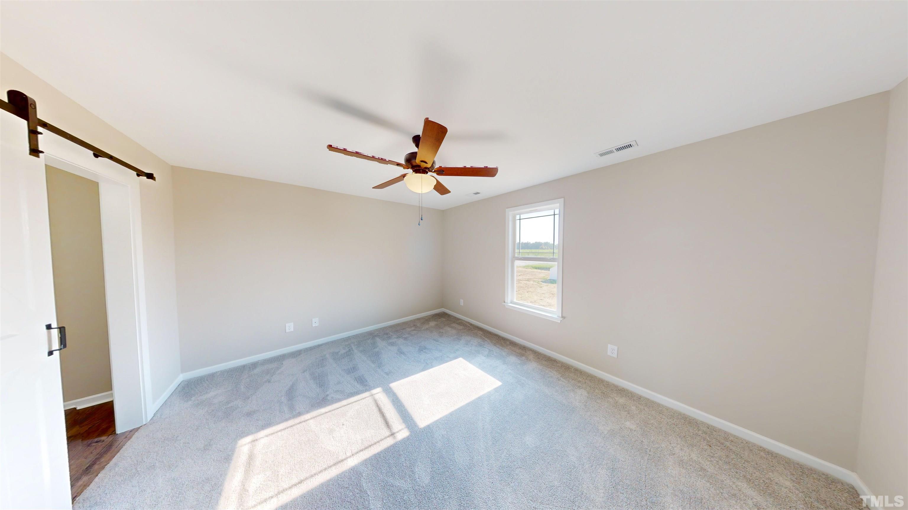 108 Mamie Road Benson, NC 27504 - Photo 14 of 31 a view of empty room with wooden floor and fan