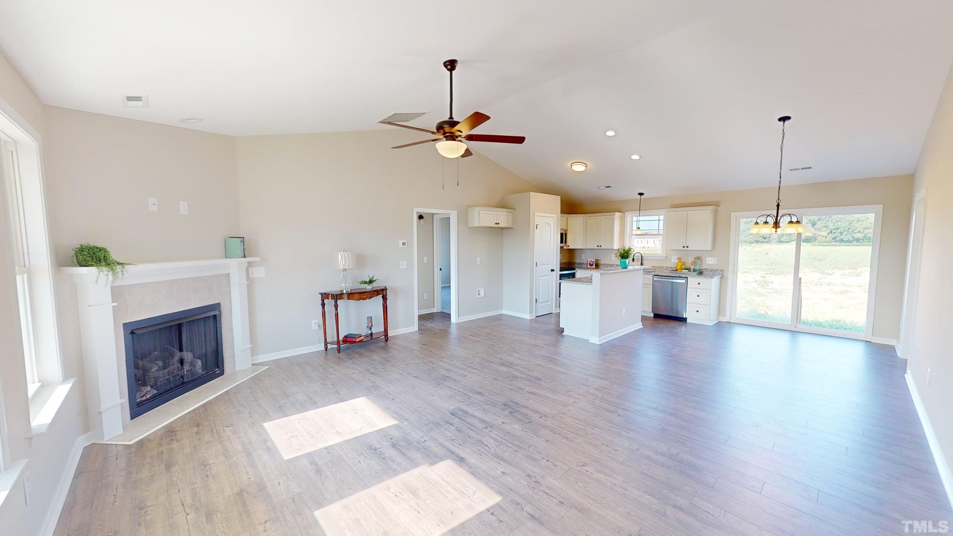 108 Mamie Road Benson, NC 27504 - Photo 4 of 31 a view of a kitchen with a stove cabinets wooden floor and a fireplace