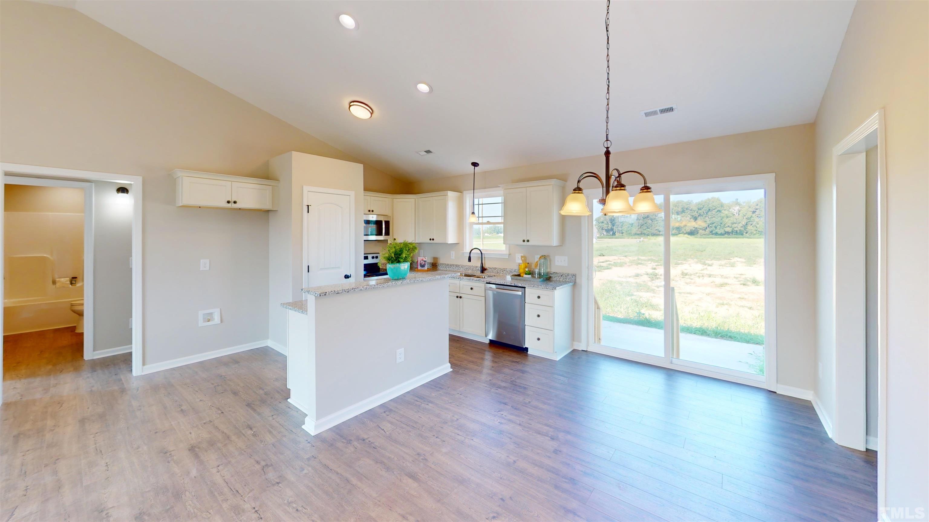 108 Mamie Road Benson, NC 27504 - Photo 5 of 31 a kitchen with stainless steel appliances granite countertop a refrigerator a sink dishwasher a stove and white cabinets with wooden floor