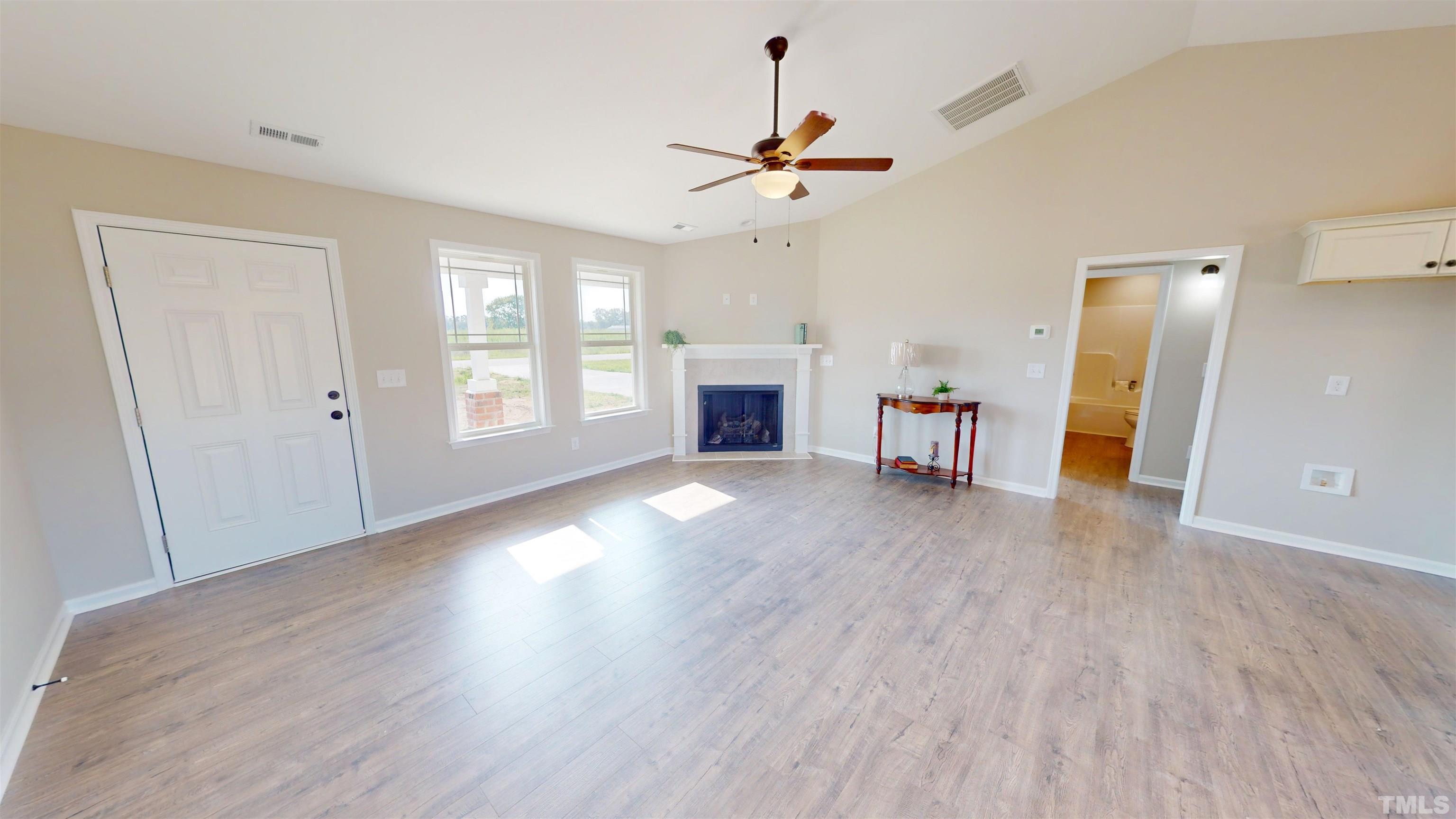 108 Mamie Road Benson, NC 27504 - Photo 6 of 31 a view of empty room with a fireplace and wooden floor