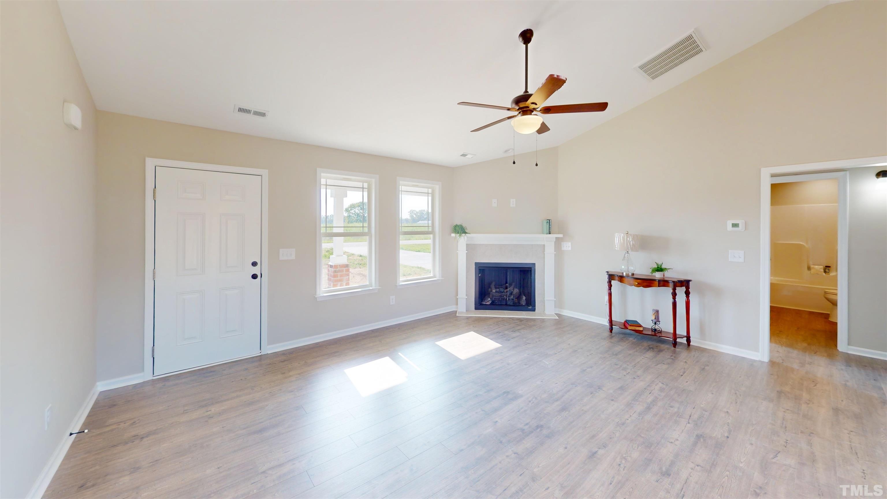 108 Mamie Road Benson, NC 27504 - Photo 10 of 31 a view of a livingroom with a fireplace a ceiling fan and windows