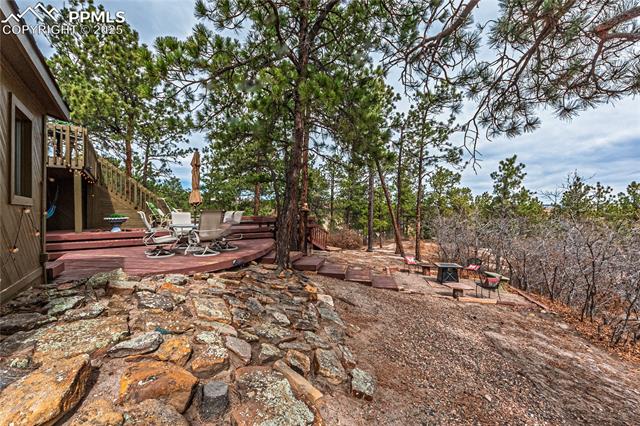 7175 Higher Ridges Court Colorado Springs, CO 80919 - Photo 40 of 50 View of yard with outdoor dining space and a deck