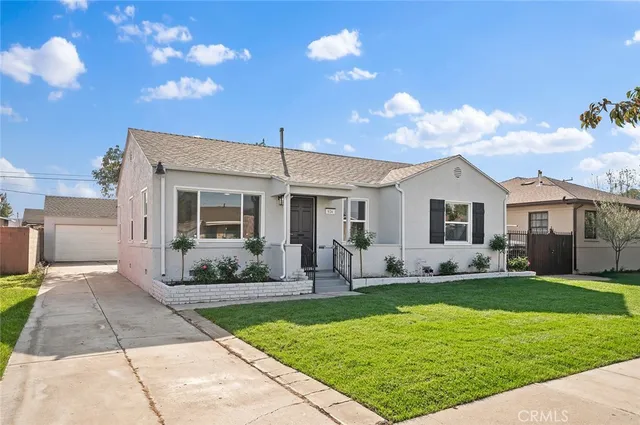 a front view of a house with a yard and outdoor seating
