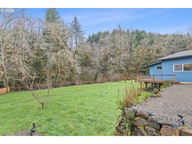 a view of a backyard with wooden fence