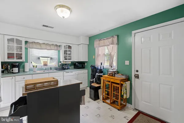 a kitchen with a sink a refrigerator and cabinets