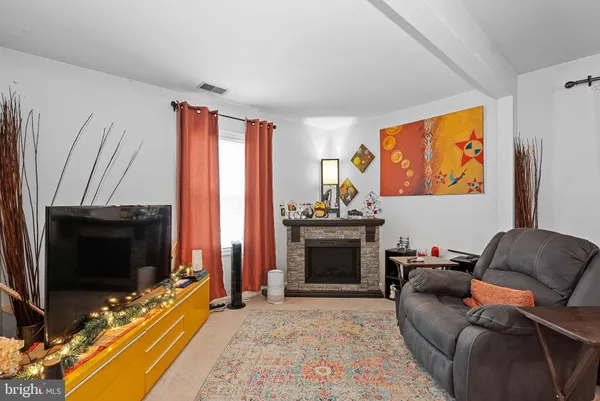 a living room with furniture a flat screen tv and a window