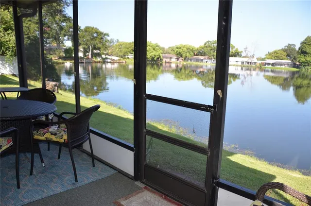 a view of a lake from a balcony with chairs