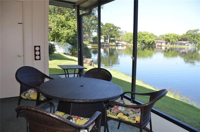 a view of a chairs and table in patio with a lake view