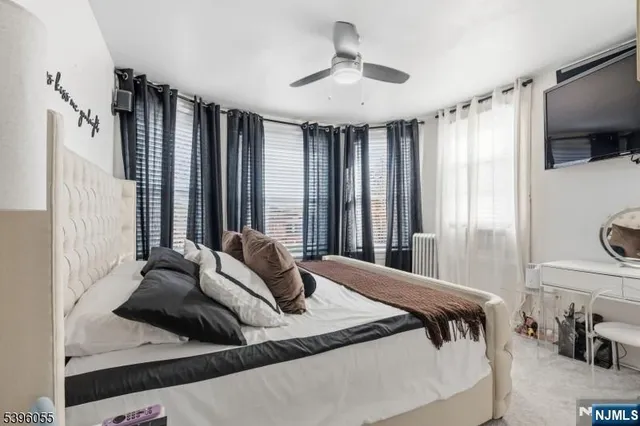 a bedroom with a bed and large window with the outer view