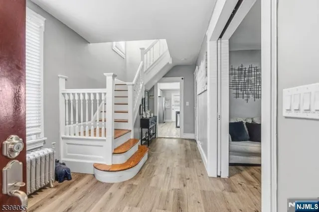 a view of a bedroom with wooden floor and furniture