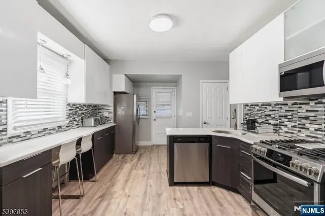 a kitchen with stainless steel appliances kitchen island granite countertop a sink stove and refrigerator