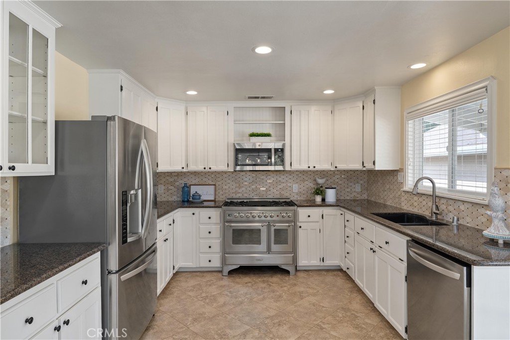 8683 Sullivan Way Durham, CA 95938 - Photo 15 of 32 a kitchen with a sink a refrigerator and white cabinets