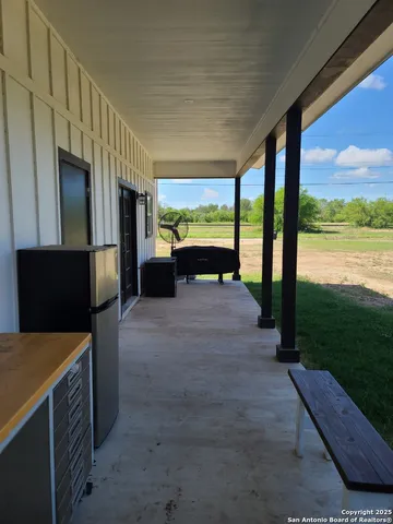 a view of a porch with furniture and floor to ceiling window