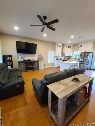 a view of kitchen with kitchen island stainless steel appliances refrigerator stove dining table and chairs
