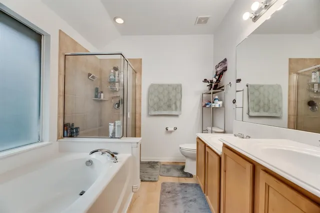 a spacious bathroom with a tub sink and mirror