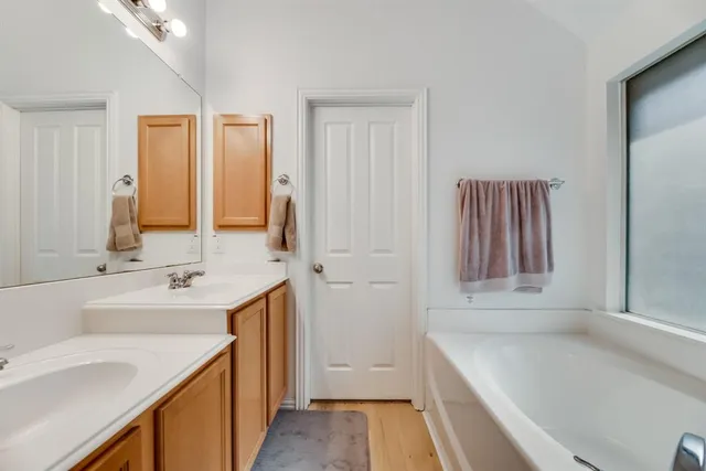 a bathroom with a tub sink and mirror