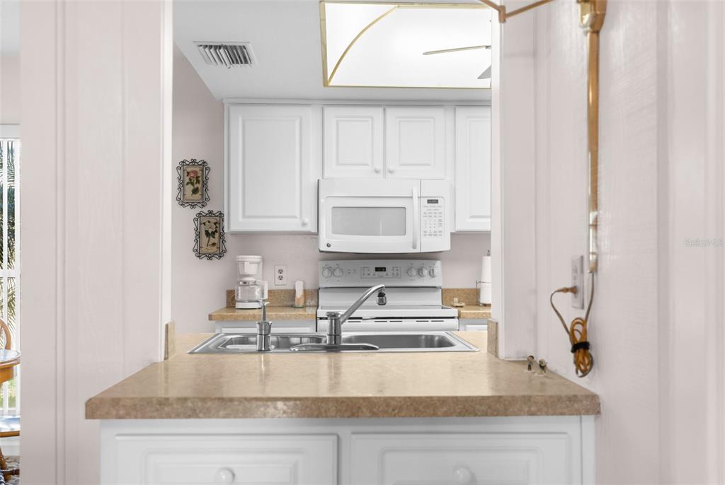 6409 Wedgewood Drive Spring Hill, FL 34606 - Photo 12 of 38 a kitchen with kitchen island granite countertop a sink a stove and cabinets