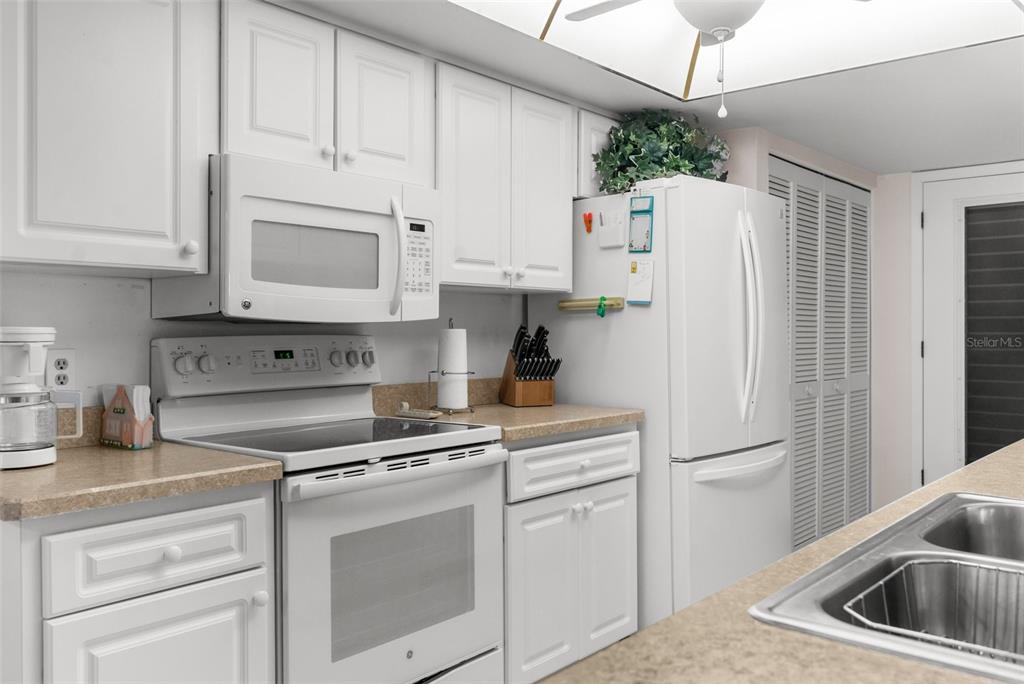 6409 Wedgewood Drive Spring Hill, FL 34606 - Photo 13 of 38 a kitchen with white cabinets and white appliances