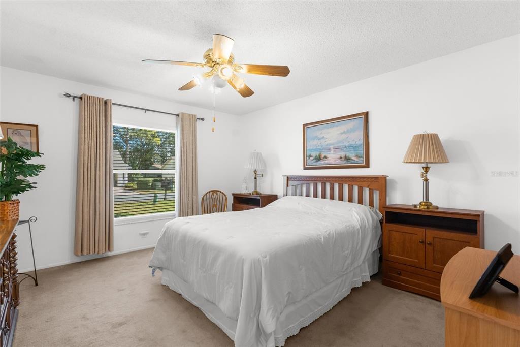 6409 Wedgewood Drive Spring Hill, FL 34606 - Photo 24 of 38 a bedroom with a large bed and a chandelier