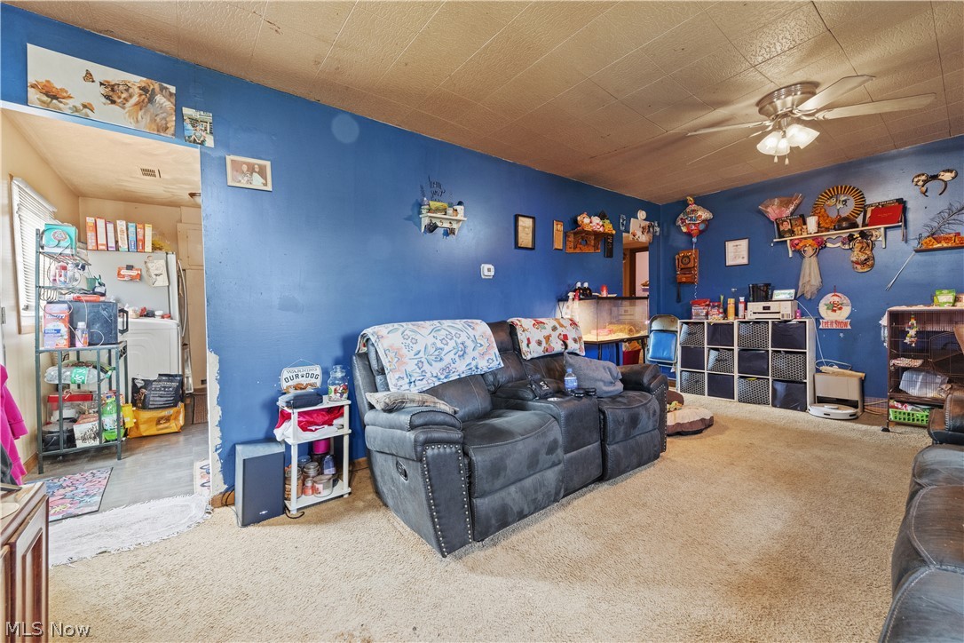 68-70 East Sunset Drive Rittman, OH 44270 - Photo 10 of 49 Carpeted living area featuring a ceiling fan with integrated lighting, a wide doorway, and a neutral ceiling