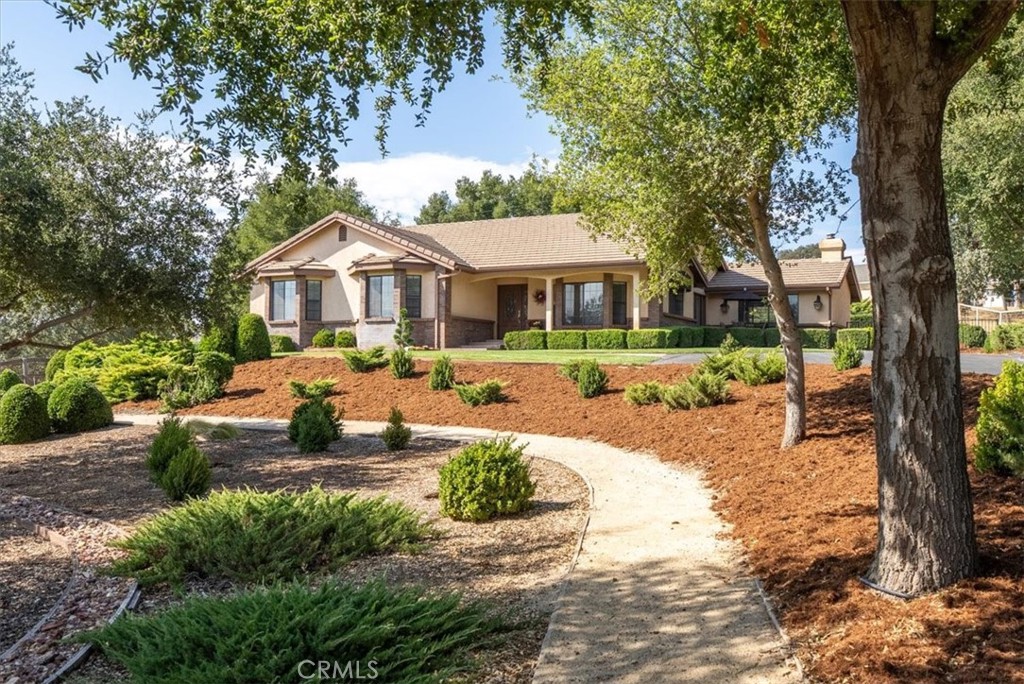 a front view of a house with a yard and trees