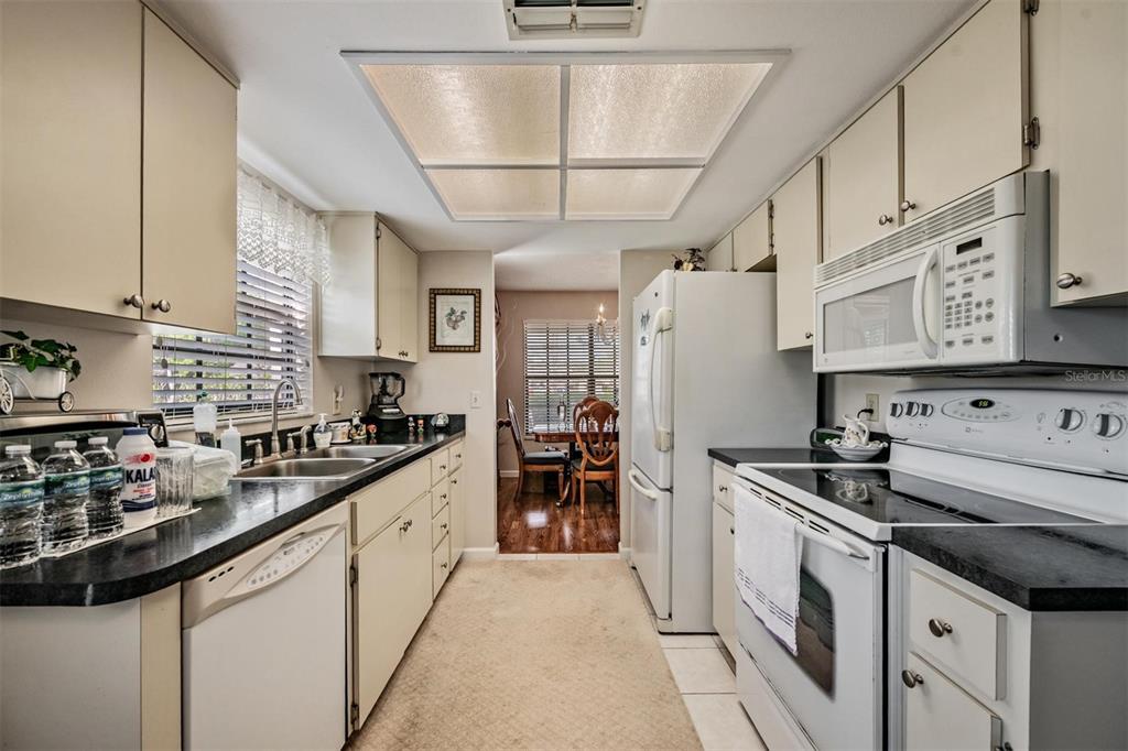 9302 Trowbridge Court New Port Richey, FL 34655 - Photo 16 of 41 a kitchen with stainless steel appliances granite countertop a sink and cabinets