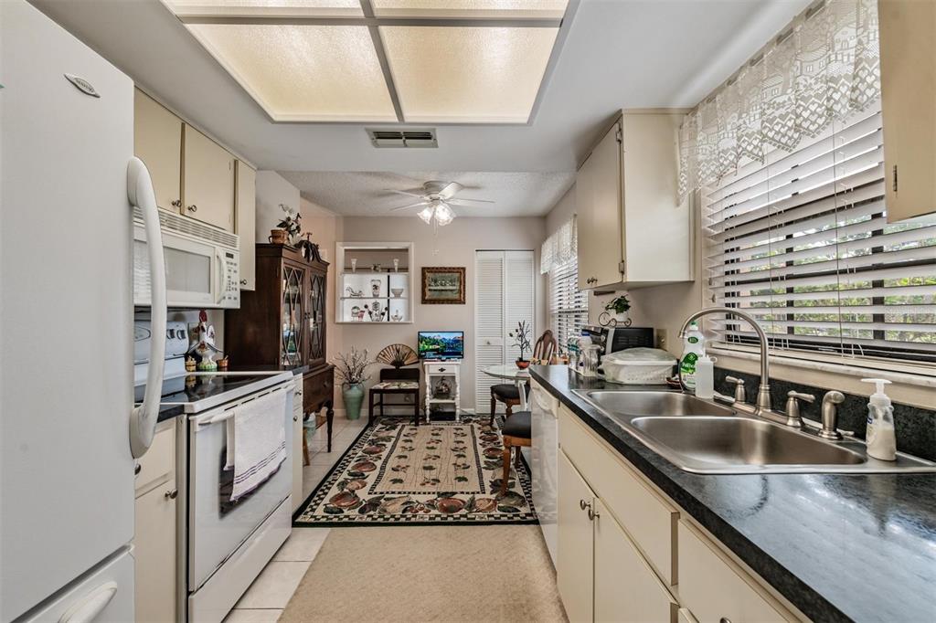 9302 Trowbridge Court New Port Richey, FL 34655 - Photo 18 of 41 a kitchen with stainless steel appliances granite countertop a sink stove and cabinets