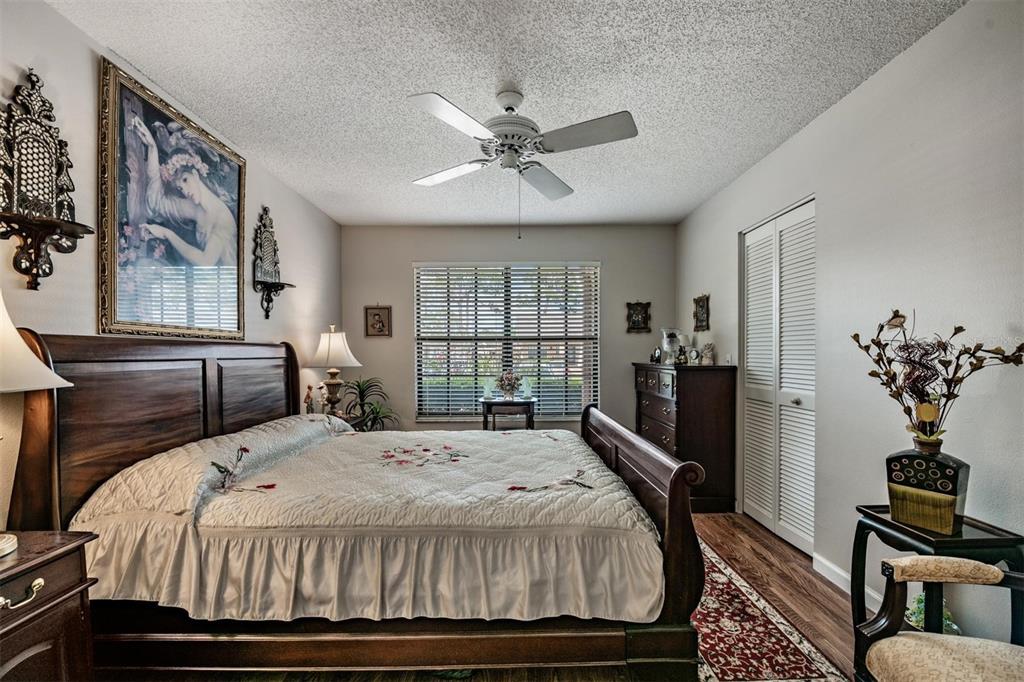 9302 Trowbridge Court New Port Richey, FL 34655 - Photo 20 of 41 a bedroom with a balcony a bed and a chandelier