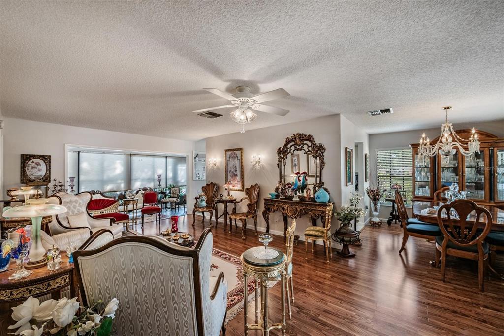 9302 Trowbridge Court New Port Richey, FL 34655 - Photo 7 of 41 a view of a livingroom and dining room with furniture floor to ceiling window and wooden floor