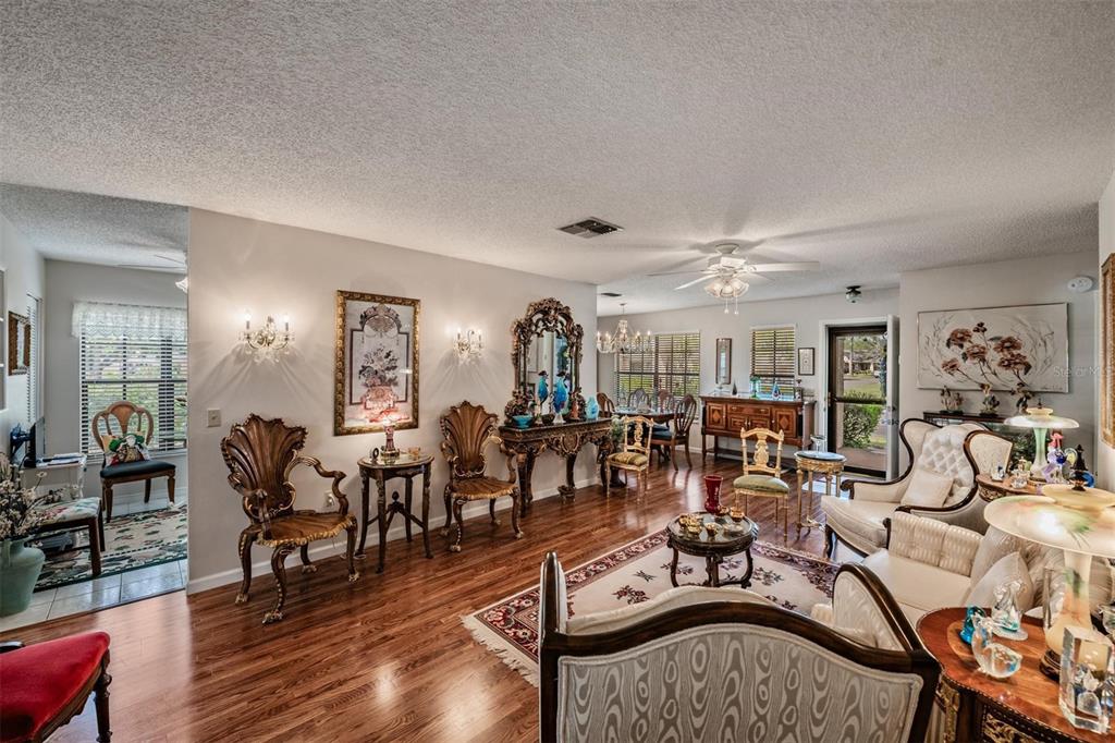 9302 Trowbridge Court New Port Richey, FL 34655 - Photo 8 of 41 a living room with lots of furniture a wooden floor and chandelier