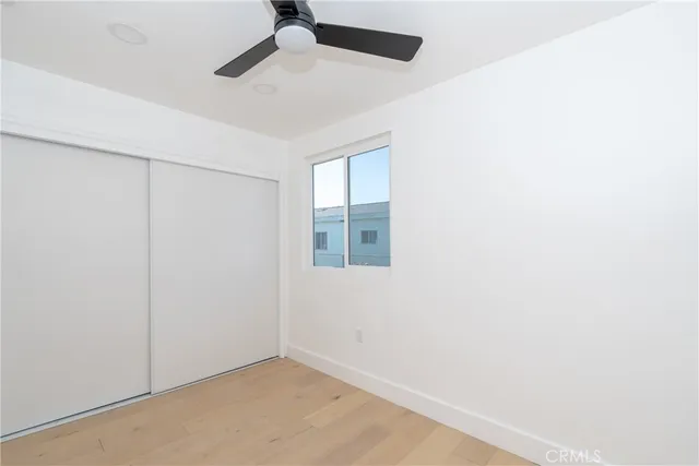 an empty room with windows and fan