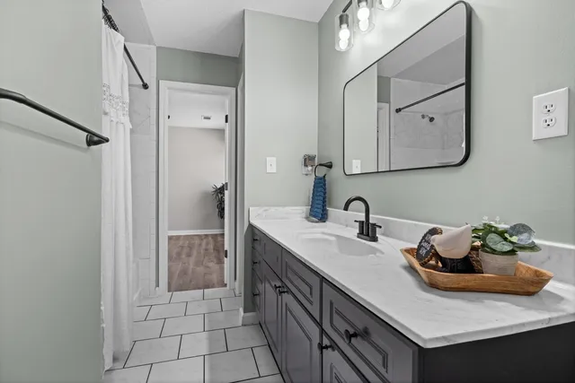 a bathroom with a granite countertop sink a mirror and a vanity