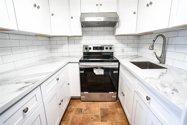 a stove top oven sitting inside of a kitchen