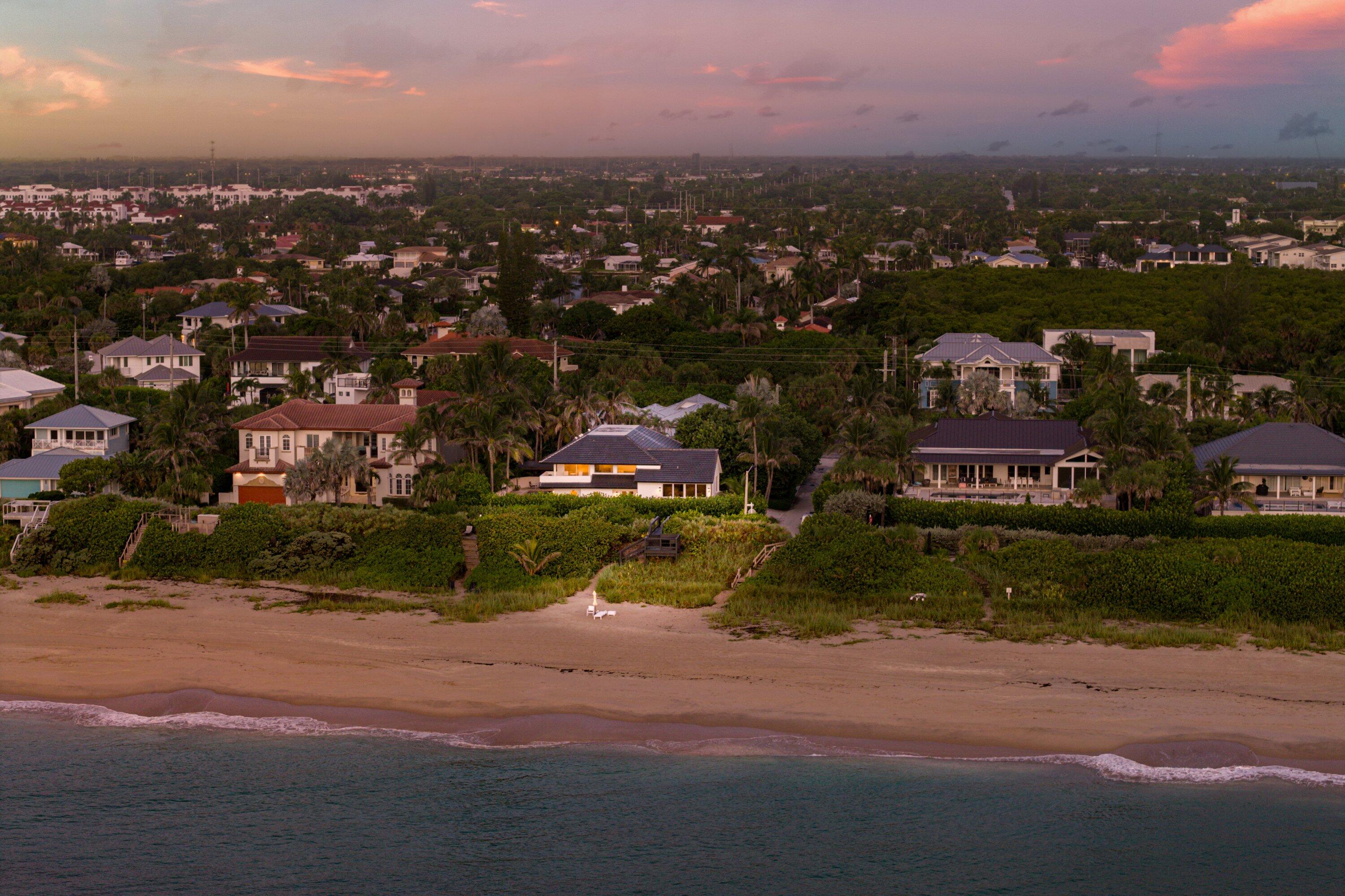 an aerial view of a house with a yard and lake view
