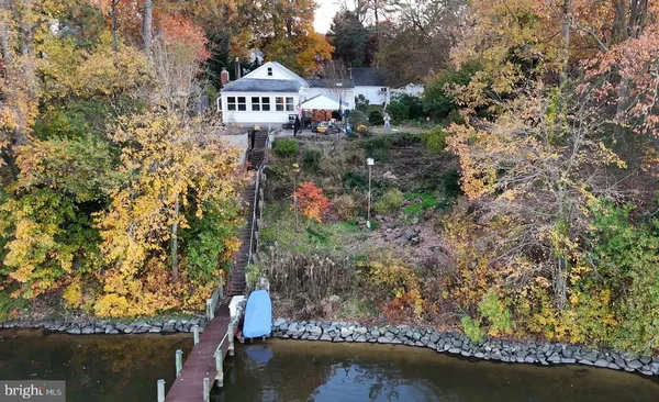 a view of a house with a yard and large trees