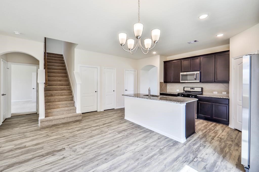 247 Sintra Lk Way Rosenberg, TX 77469 - Photo 6 of 28 a large kitchen with kitchen island stainless steel appliances sink and wooden floor