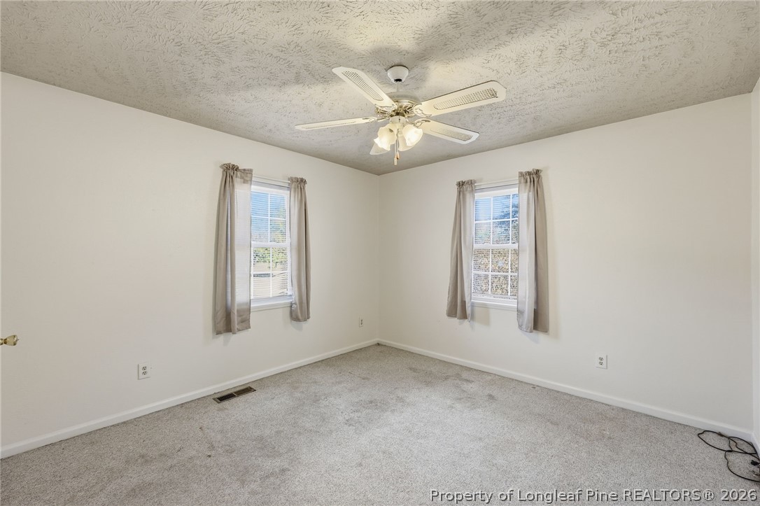 223 Broadwell Road St. Pauls, NC 28384 - Photo 16 of 28 an empty room with windows and fan