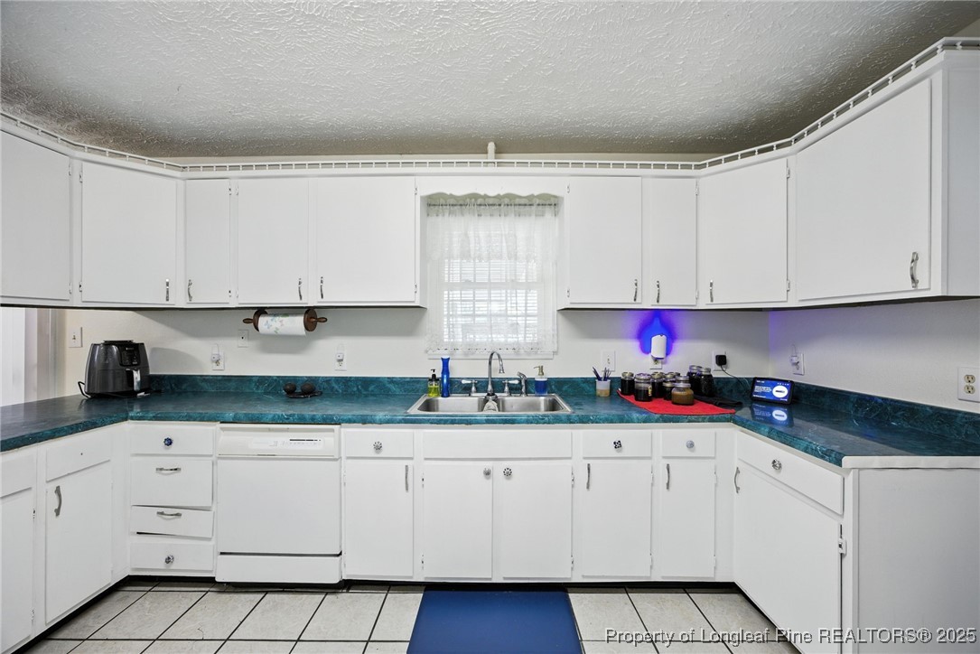 223 Broadwell Road St. Pauls, NC 28384 - Photo 18 of 28 a kitchen with granite countertop white cabinets and white appliances