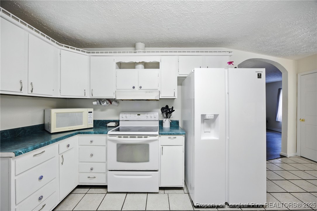 223 Broadwell Road St. Pauls, NC 28384 - Photo 19 of 28 a kitchen with white cabinets and white appliances