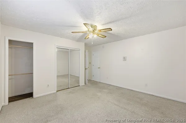 an empty room with closet and a chandelier fan