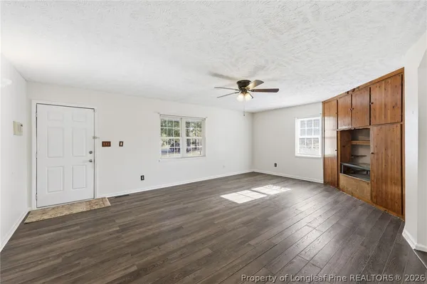 a view of empty room with wooden floor and window