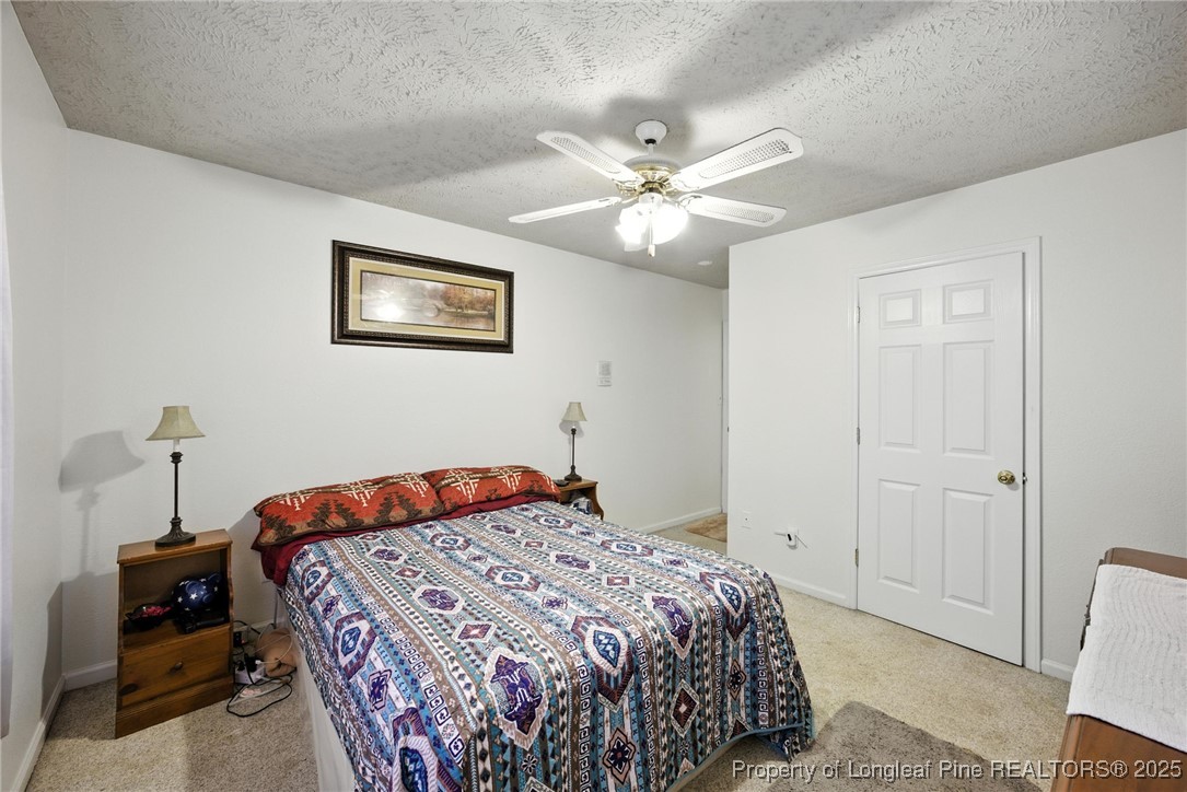 223 Broadwell Road St. Pauls, NC 28384 - Photo 7 of 28 a bedroom with a bed and a chandelier