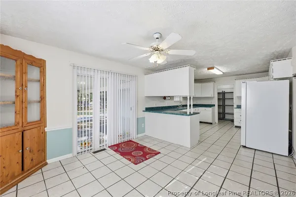a kitchen with a refrigerator and white cabinets