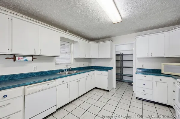 a kitchen with granite countertop a sink and cabinets