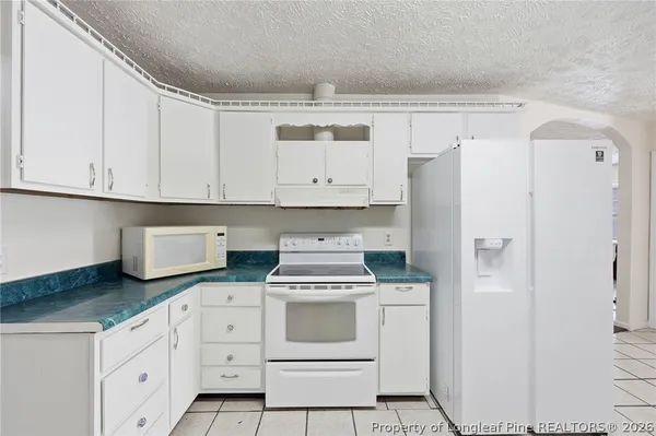 a kitchen with white cabinets and white appliances