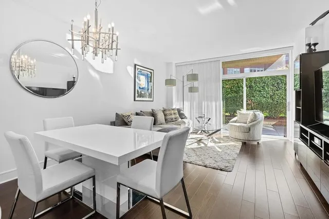a view of a dining room with furniture a chandelier and wooden floor