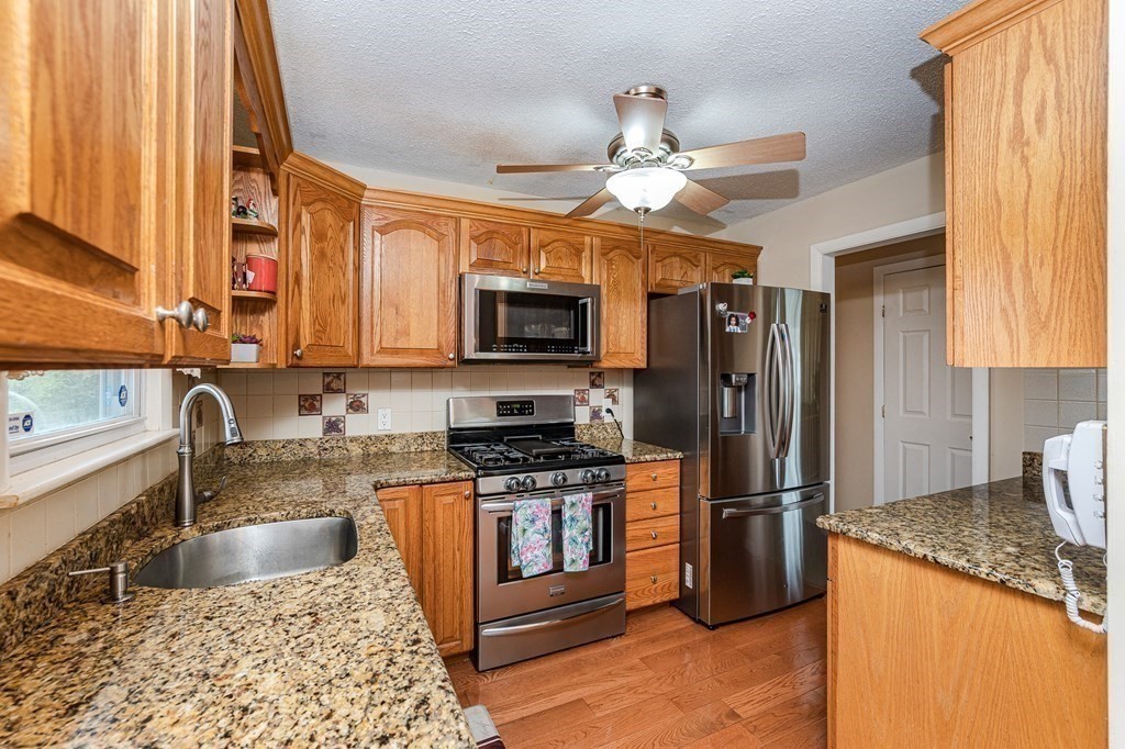 2 Lorenzo Road Lawrence, MA 01843 - Photo 15 of 42 a kitchen with stainless steel appliances granite countertop a refrigerator a stove top oven a sink and dishwasher