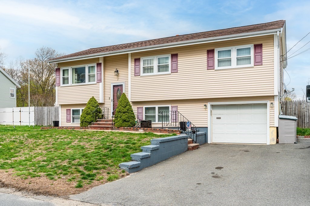 2 Lorenzo Road Lawrence, MA 01843 - Photo 4 of 42 a front view of a house with a yard and garage