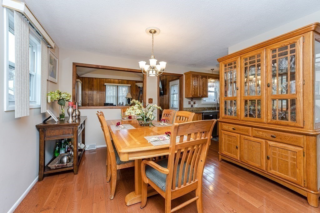 2 Lorenzo Road Lawrence, MA 01843 - Photo 9 of 42 a dining room with wooden floor a chandelier a wooden table and chairs